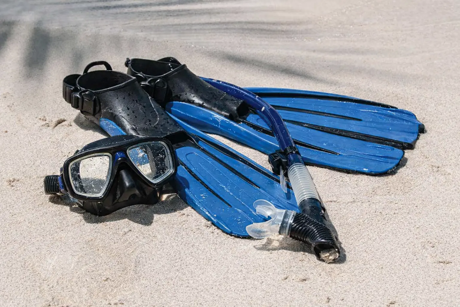 藍色開放式浮潛蛙鞋、黑色潛水靴及雙鏡面浮潛面罩，適合香港島嶼及沙灘裝備租借