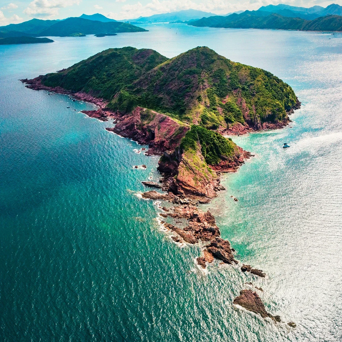 Aerial view of Port Island Hong Kong with red rock coastline and turquoise water