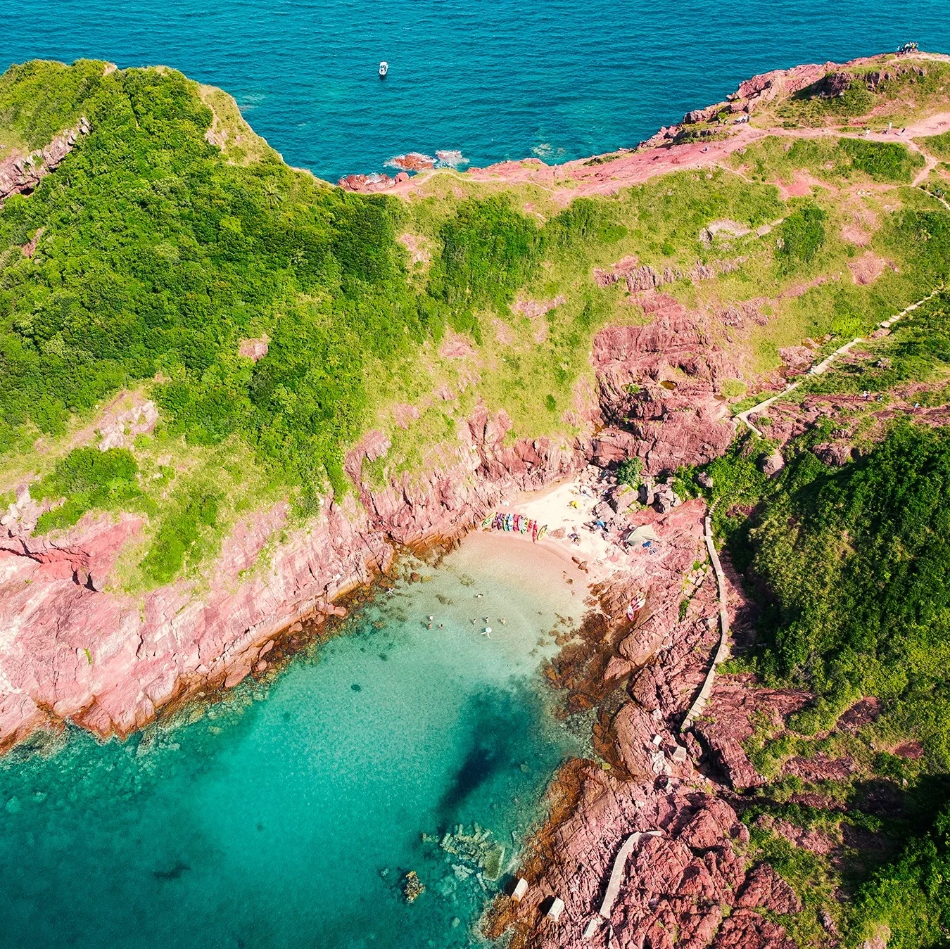 Aerial view of Port Island Hong Kong red sedimentary rock beach with turquoise water