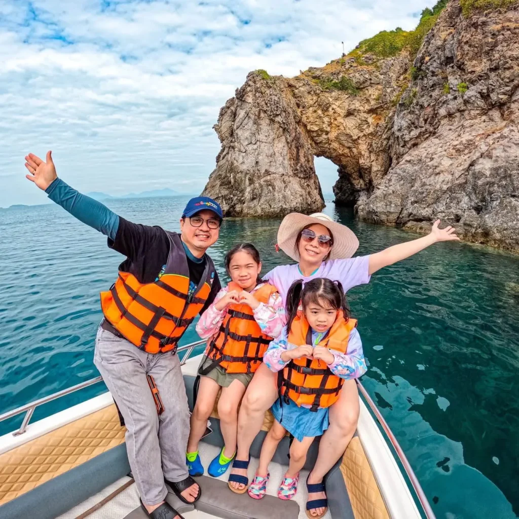 Family enjoying a boat trip near Hong Kong island sea arch
